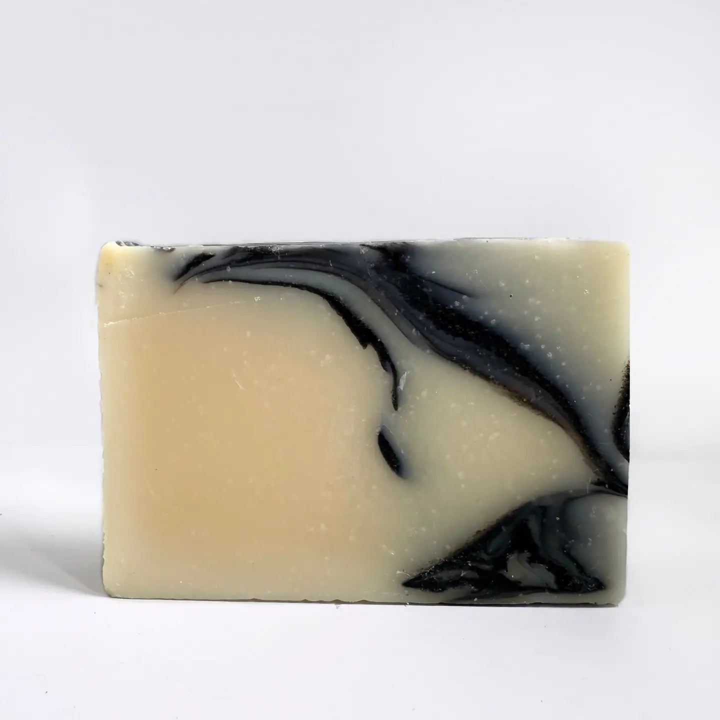 Growing Wilder The Explorers Soap has a creamy base, bold black swirls, and a sandalwood bergamot scent for luxurious skincare.