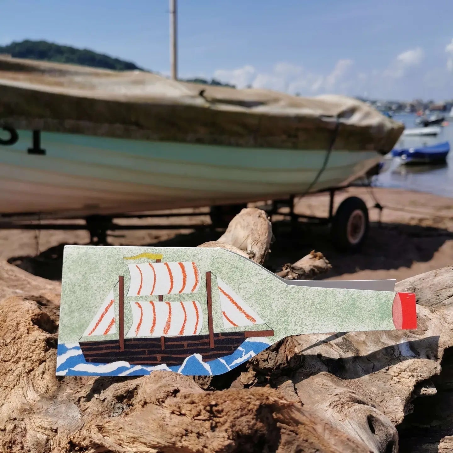 Hadley Ship In A Bottle Greeting Card with driftwood, cutout ship in bottle, and classic boat background. Nautical gift card.