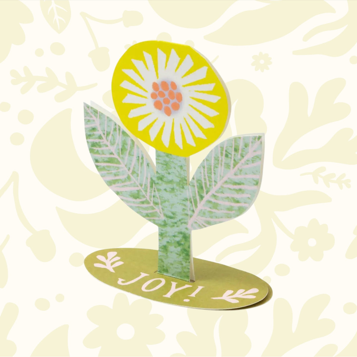 Hadley Joy Flower Stand Up Greeting Card with green leaves, yellow bloom, oval base reads "JOY!"—unique floral celebration card.