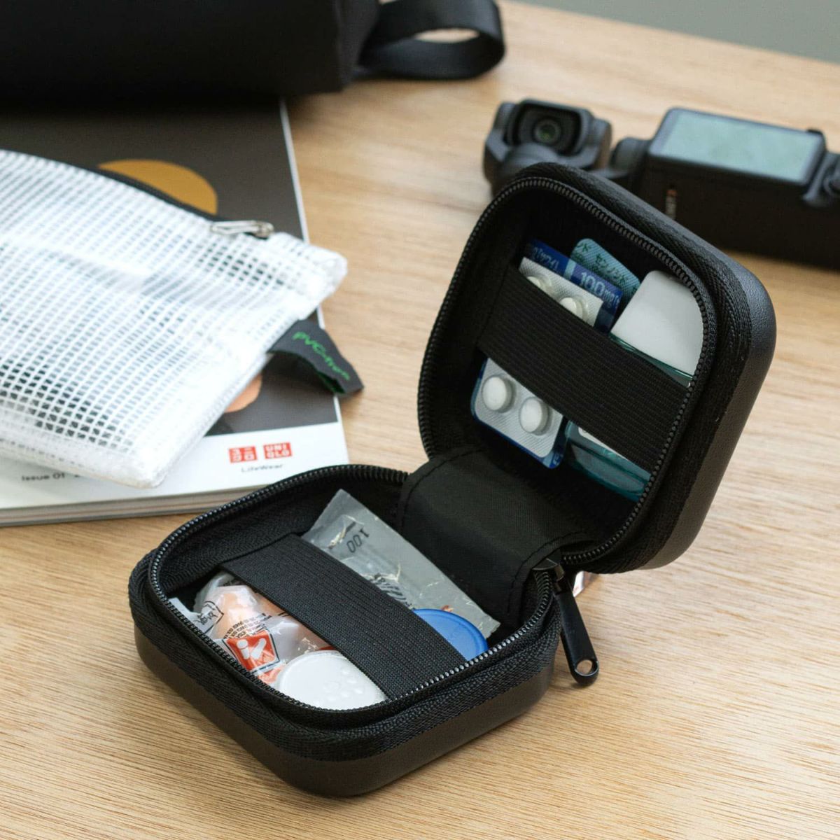 Open orange Hightide Nahe Hardshell Case Mini on desk, organized with medicine, pills, and personal essentials inside.