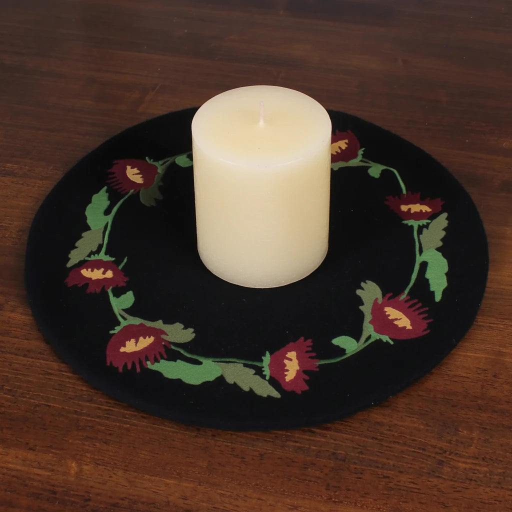 Shop The Home Collection Primitive Folk Flowers Firkin Candle Placement—round white candle on black embroidered mat decor.