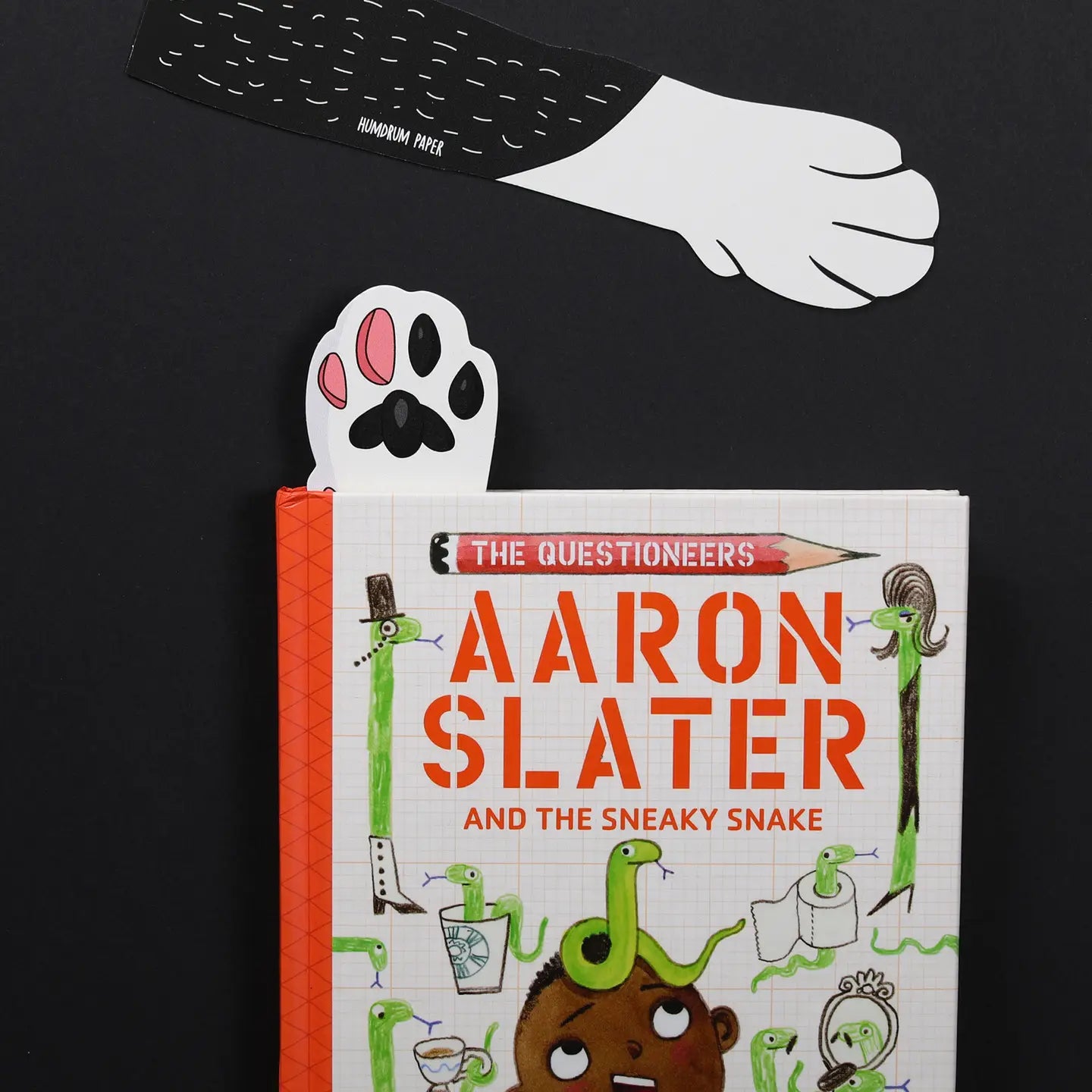 Cat Paw bookmark secures Aaron Slater and the Sneaky Snake—perfect cat lover gift, unique book accessory, black background.