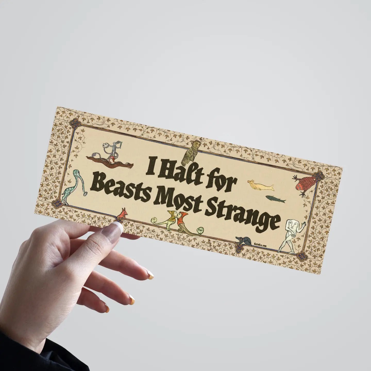 Hand holding Betiobca “I Halt For Beasts Most Strange” bumper sticker, beasts frame durable vinyl decal, unique gift idea.