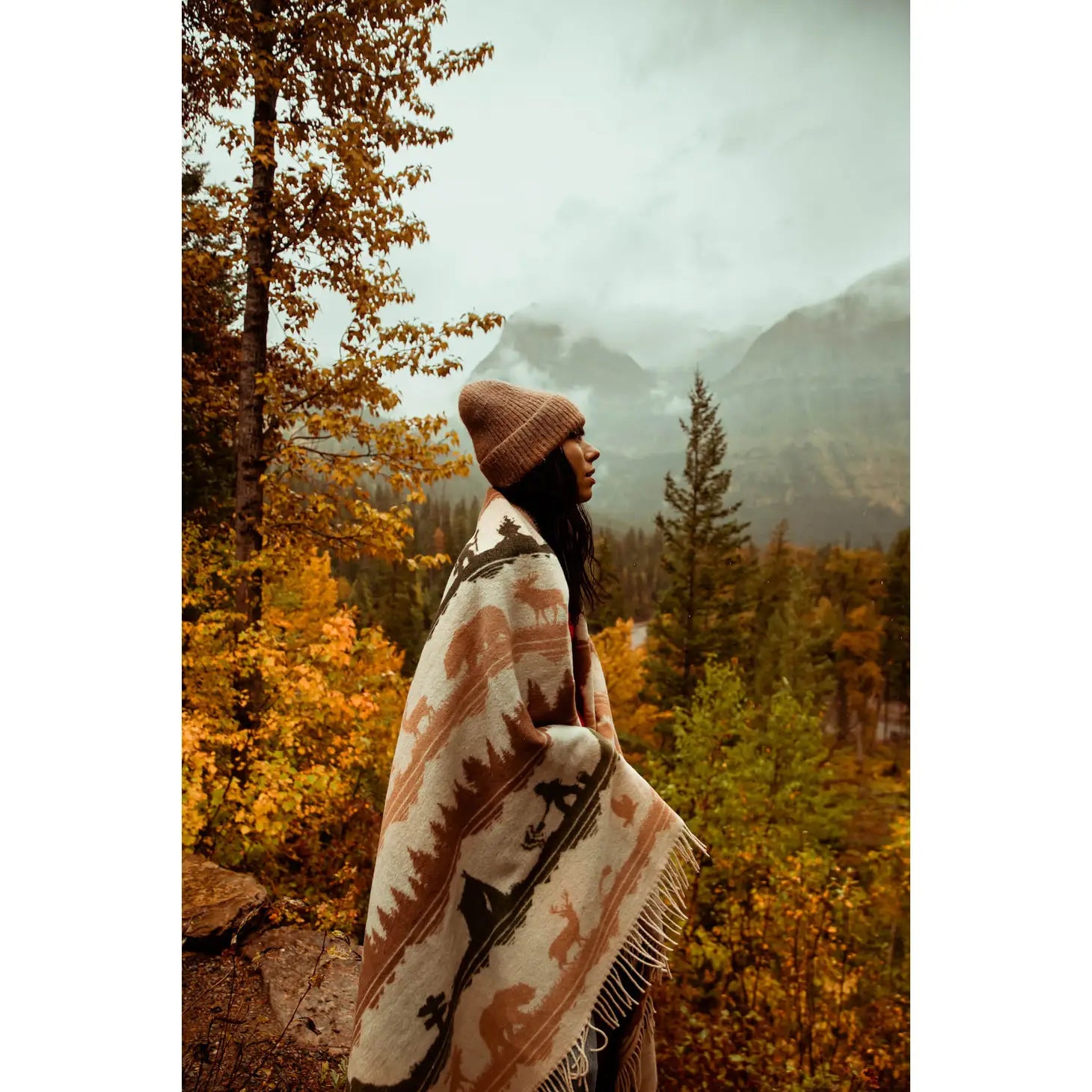 The Sackcloth & Ashes Smokey Bear Blanket - Smokey Ranger features a stunning nature-themed design with silhouettes of trees, mountains, animals, and hikers in muted earth tones. This distinctive blanket not only supports wildfire prevention but is also made from recycled materials for an eco-friendly touch.