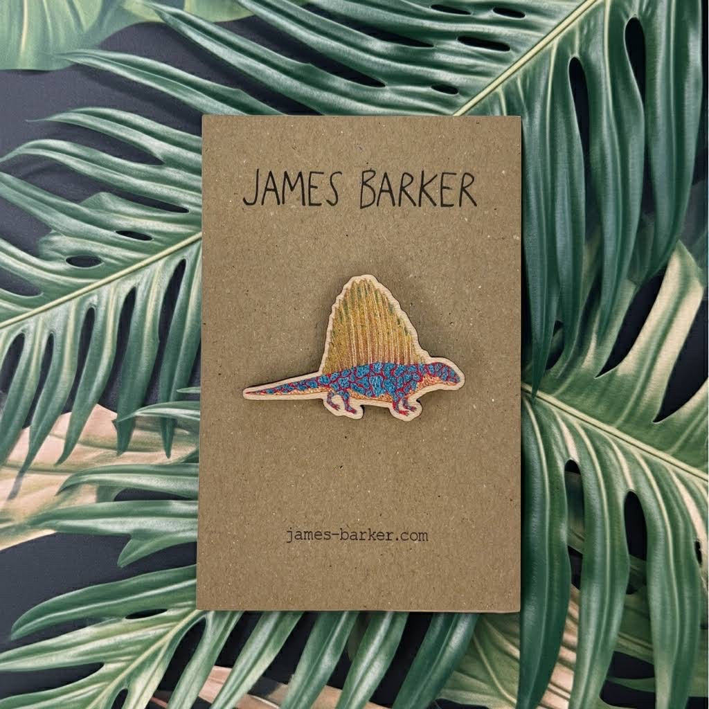 Forager Provisions LTD James Barker wooden Dimetrodon pin on a branded display card against a tropical leaf background.