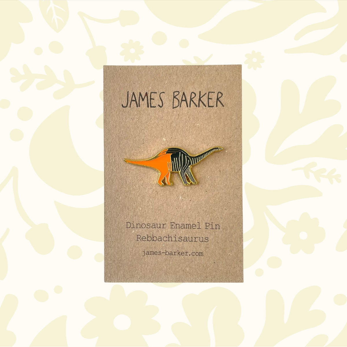 James Barker Rebbachisaurus Sauropod Dinosaur Enamel Pin displayed on brown card with unique James Barker illustration.