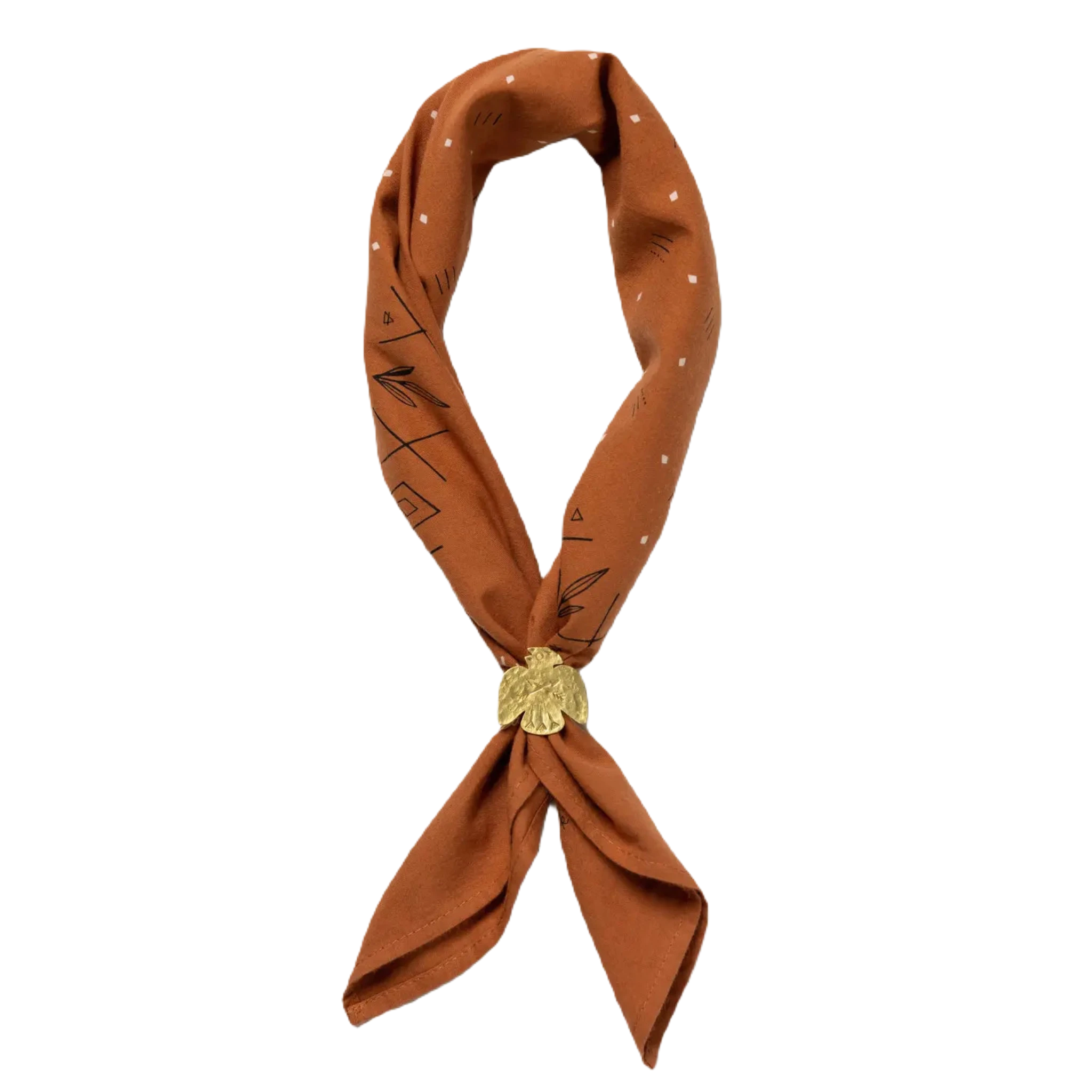A rust scarf with white geometric patterns, styled in a loop and secured by the Jenni Earle Brass Thunderbird Handmade Bandana Slide, brings a touch of western style.