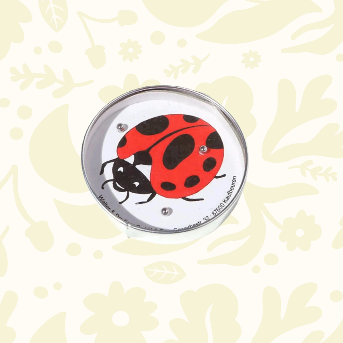 The Die Blechfabrik e.K Ladybird Puzzle Ball Maze features a circular design with an illustration of a red and black ladybug, held securely by small steel balls. This handmade game is perfect for puzzle enthusiasts, offering hours of engaging fun.