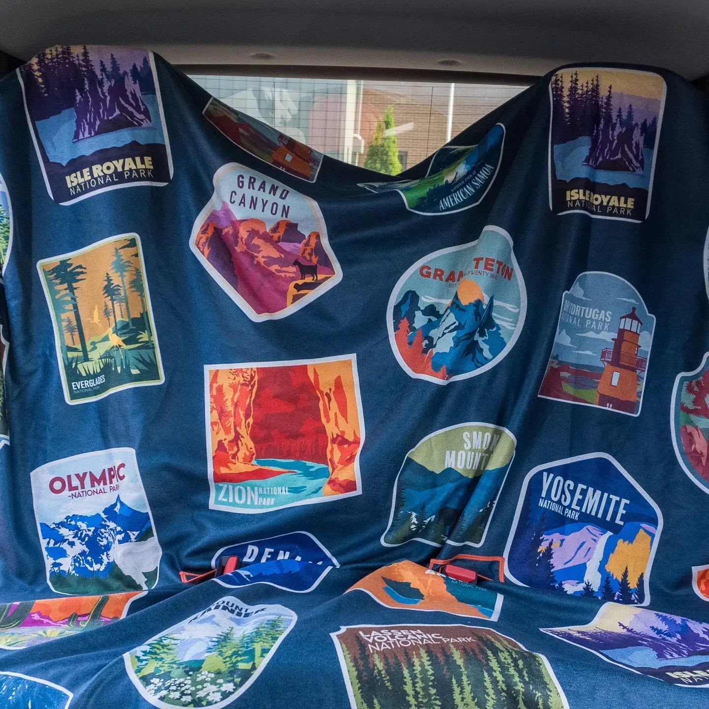 Forager Provisions LTD Sprints car seat towel featuring a dark blue fabric with colorful National Parks graphic patches.