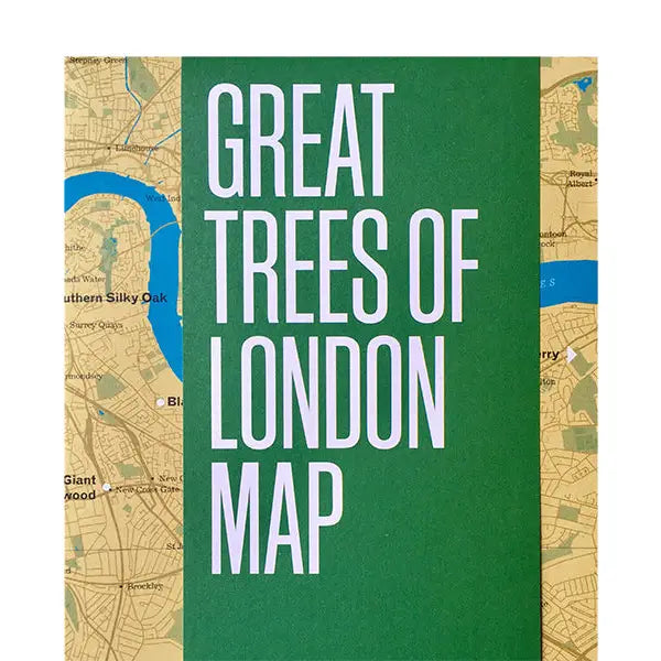 Cover of the "Blue Crow Media Great Trees Of London Map" featuring a green title block overlaid on a detailed map of London's areas, printed on recycled FSC-certified paper, all displayed on a wooden surface.