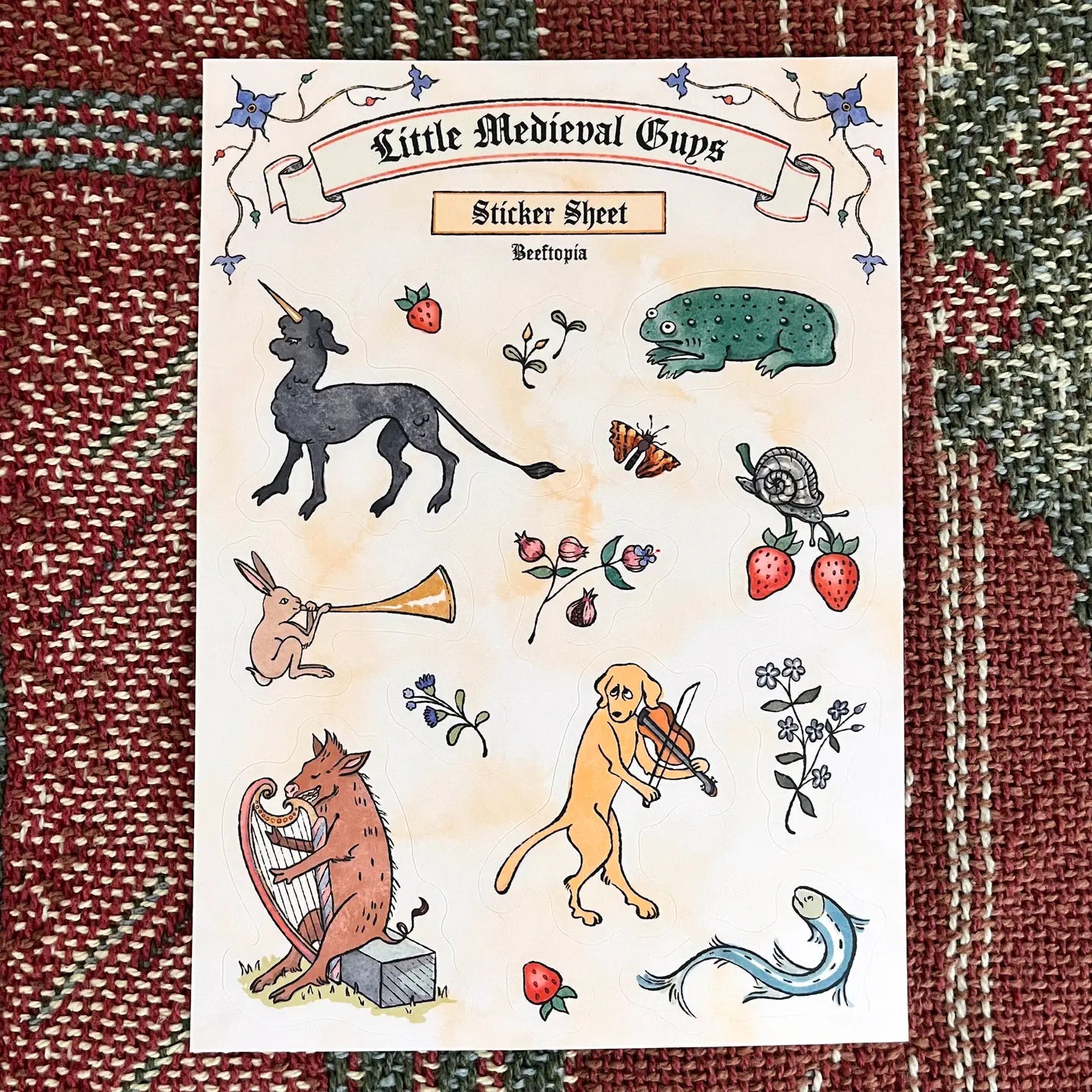 Beeftopia Medieval Creatures sticker sheet—waterproof vinyl with fruits, insects on vibrant red-green background. Collector’s item.