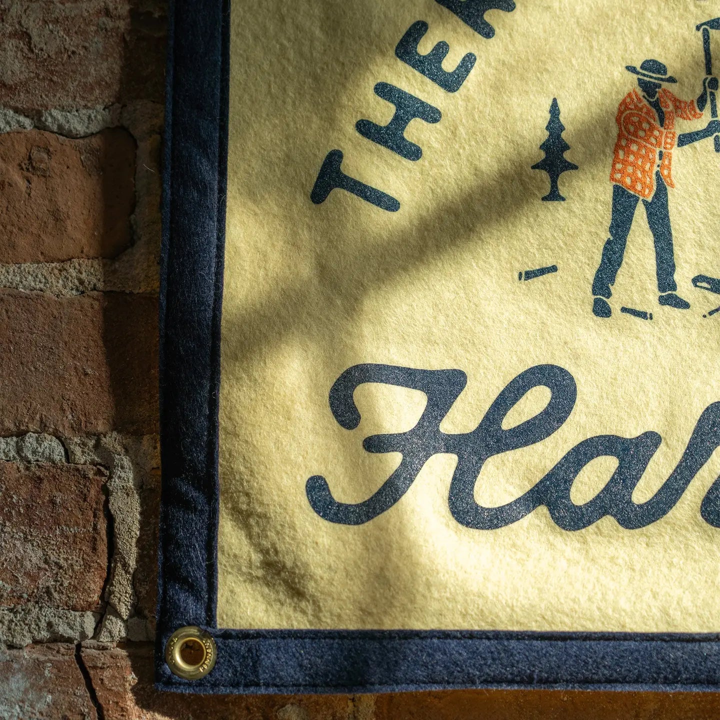 Oxford Pennant camp flag on a brick wall reads "There Is No Substitute For Hard Work"—inspiring office or home wall decor.