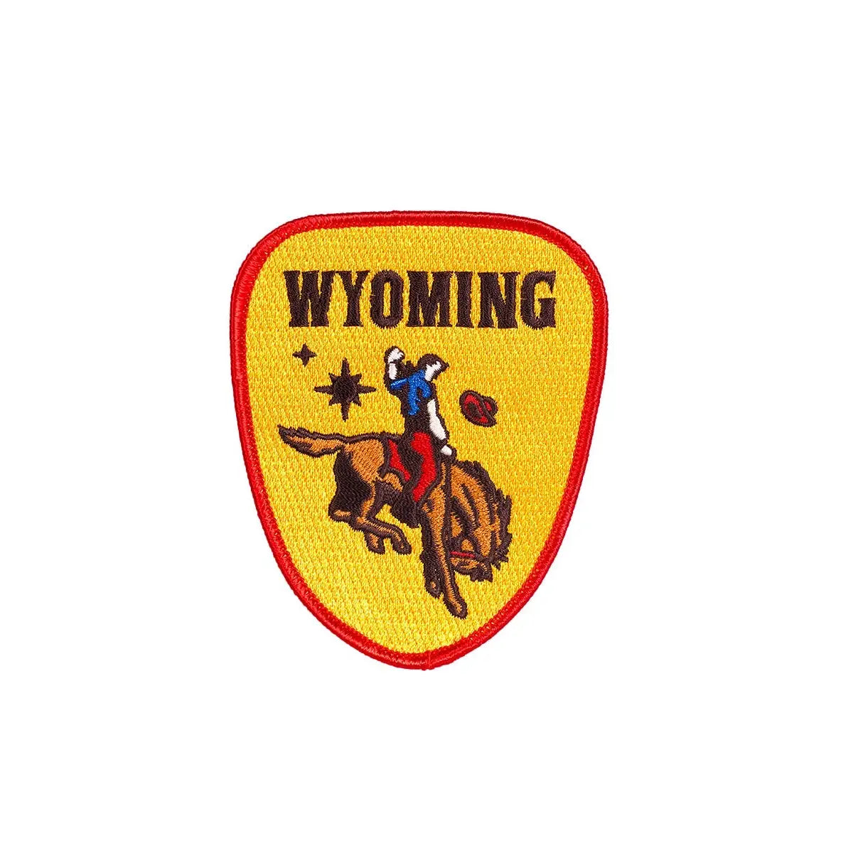 The Oxford Pennant Wyoming Cowboy Patch is a gold embroidered patch with a red border, featuring a cowboy riding a bucking horse. The word "WYOMING" is proudly displayed at the top, capturing Wyomingite pride.