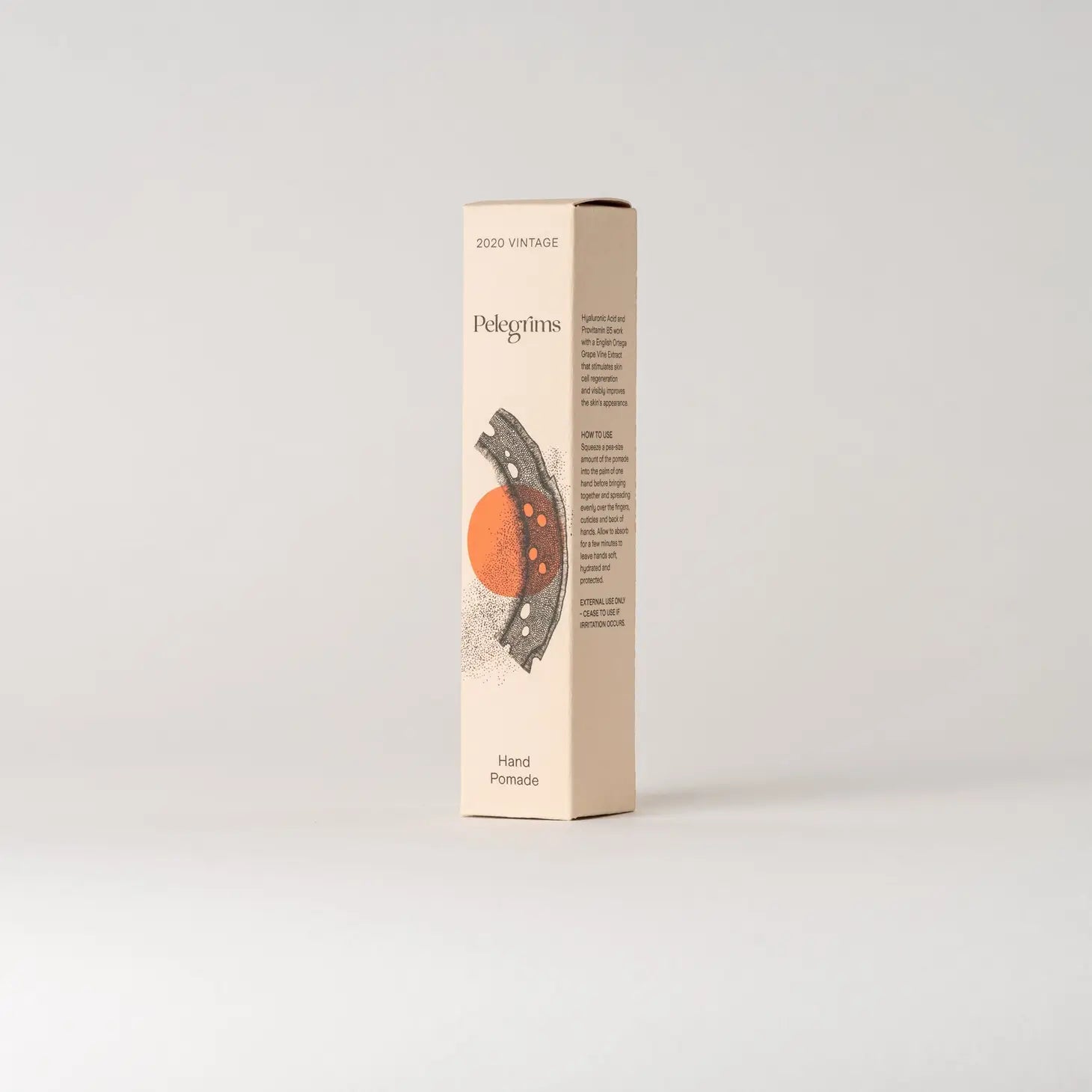 Tall beige box labeled "2020 VINTAGE" and "Pelegrims Hand Pomade," featuring an illustration of an orange circle and abstract design. Enriched with nourishing English Ortega Grape Extract.