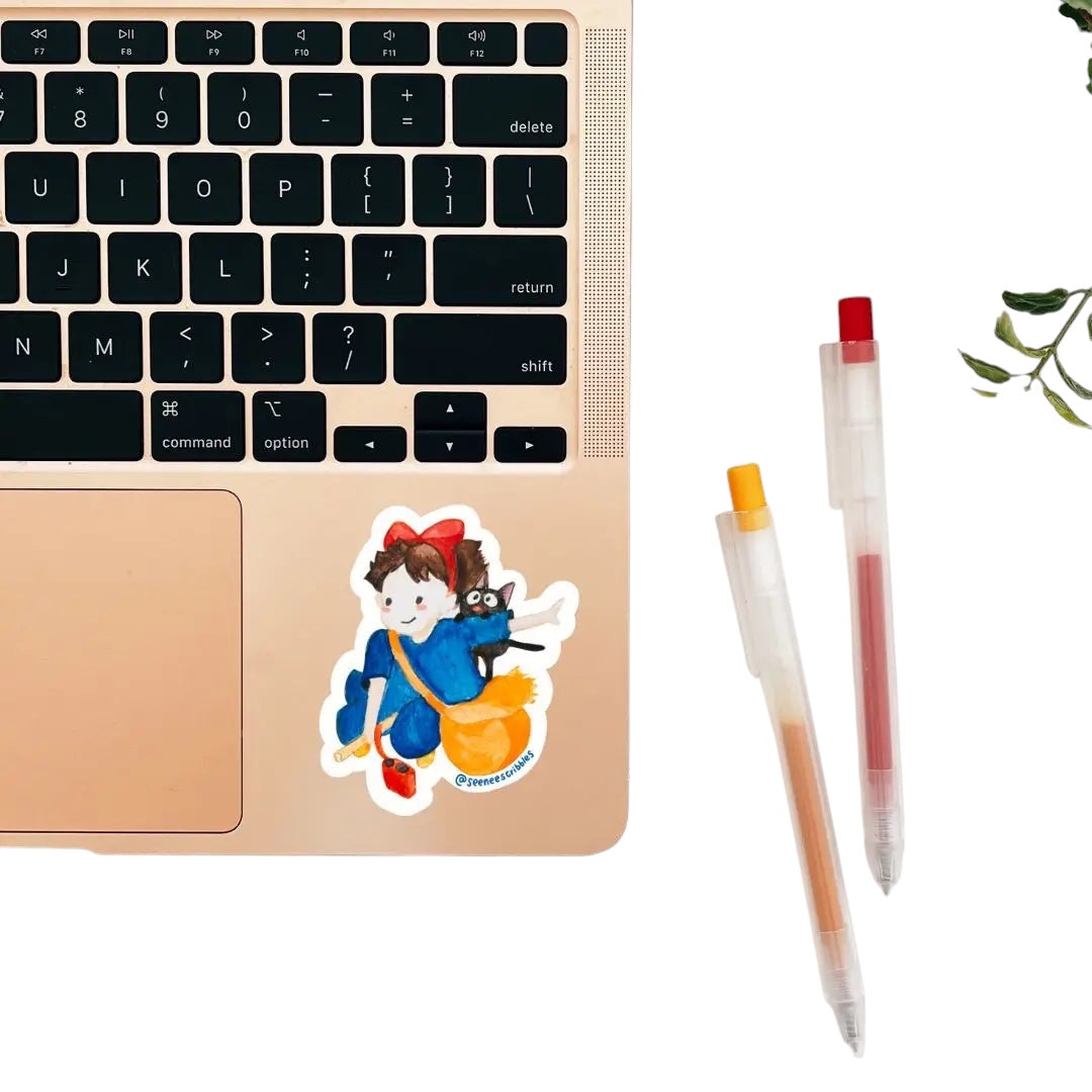 The Seenee Scribbles Studio Ghibli Inspired Kiki Delivery Service Sticker features a charming cartoon girl in a blue outfit with a red bow, holding a broomstick and accompanied by an adorable black cat. Encircled by green leaves on a wooden surface, she evokes the enchanting essence of Kiki's Delivery Service. Ideal for vinyl stickers!