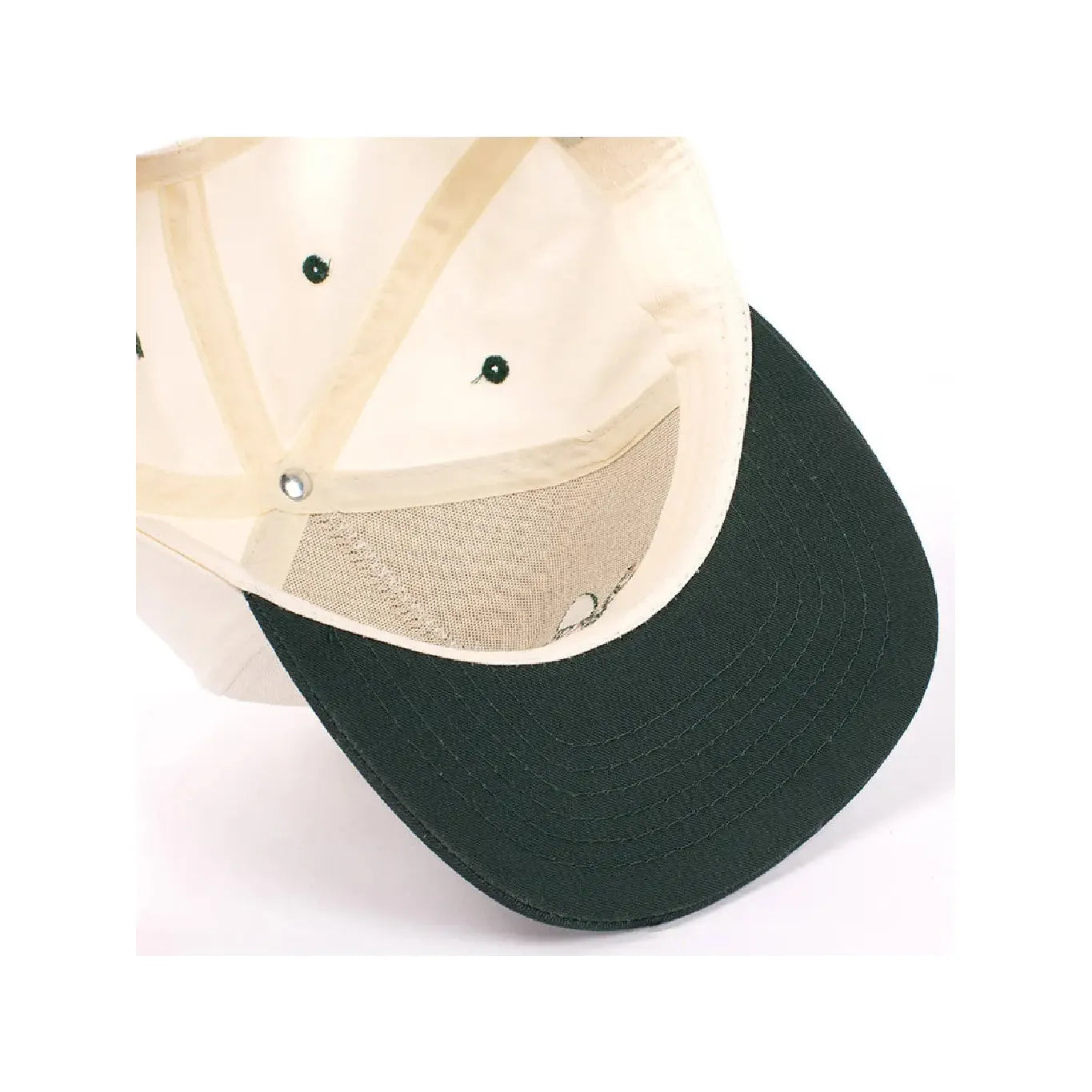 Underside of the Sendero Provisions LeRoy Brown Cap, featuring a beige top with a green brim and stitching, crafted from durable cotton canvas and Made in Mexico, showing the internal structure and sweatband.