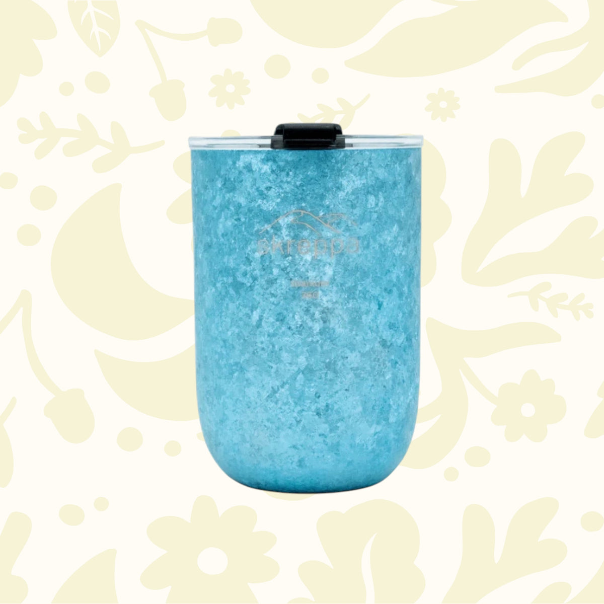 Skreppa 350ml Double Wall Titanium Tumbler on a floral, leaf-patterned pale surface for stylish drinkware lovers.