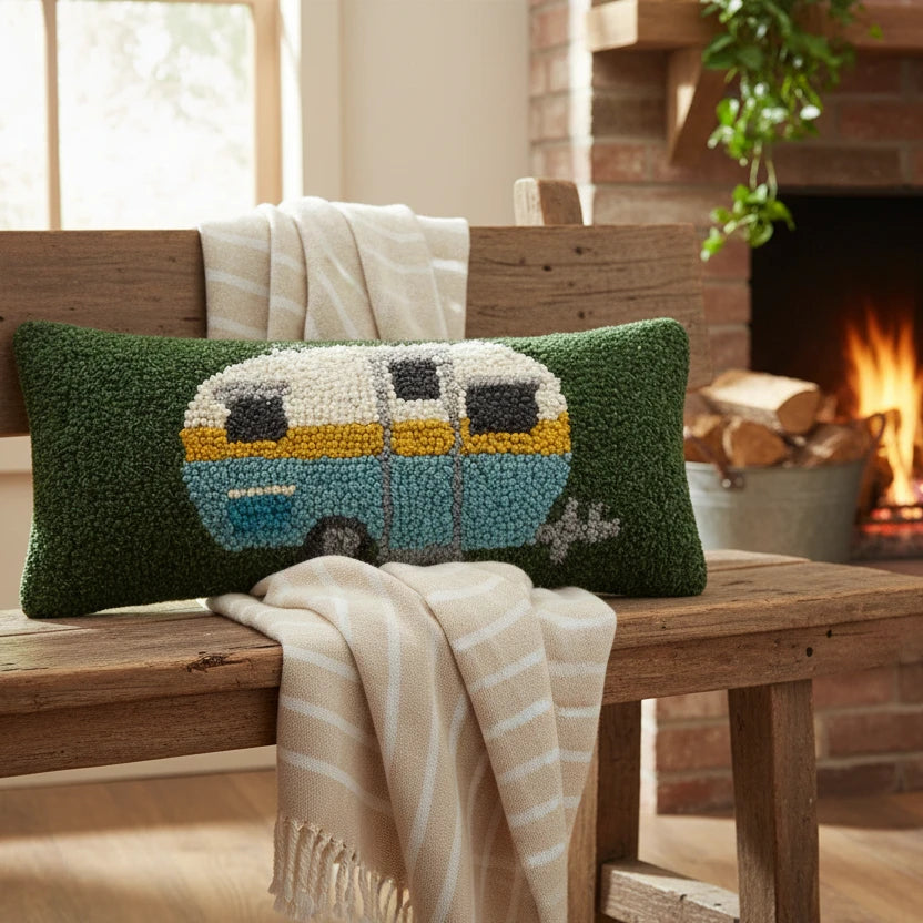 Peking Handicraft Camper Wool Hook Cushion 12x5” decorates bench with a striped throw, creating cozy fireplace seating ambiance.