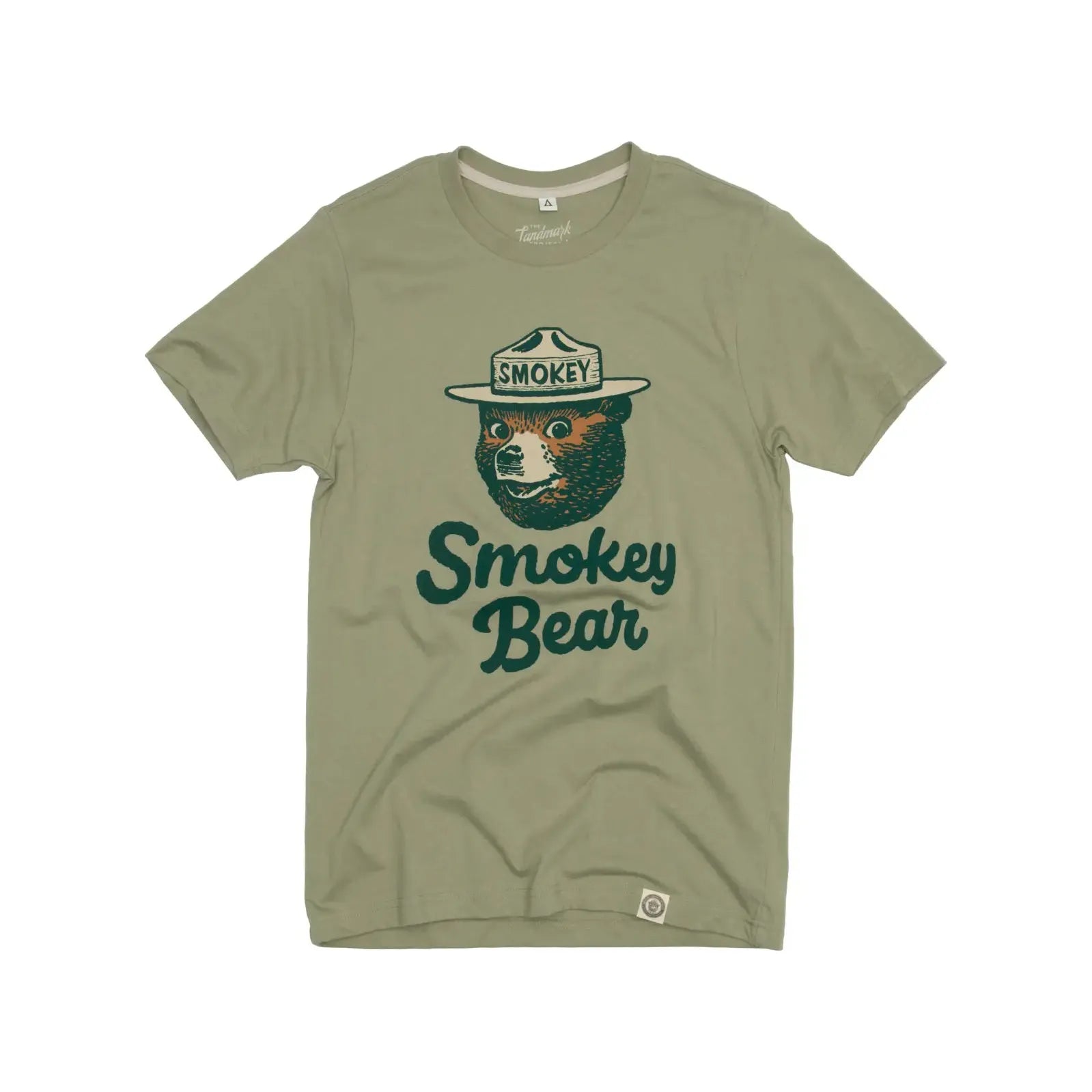 The Landmark Project Heritage Smokey Bear T-Shirt in Bay Leaf features a graphic of Smokey Bear wearing a ranger hat, with the text "Smokey Bear" below. This sustainably made tee boasts vintage colors that enhance its timeless appeal.