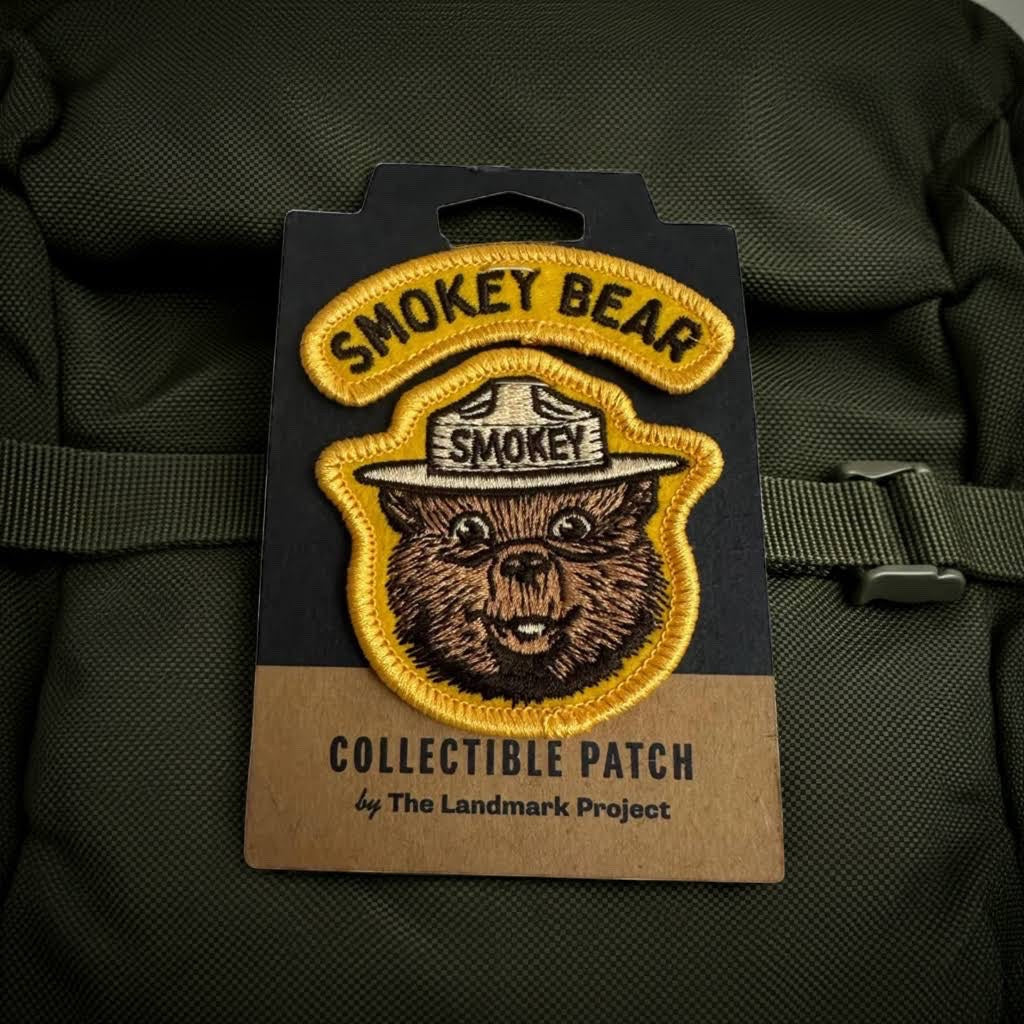 Forager Provisions LTD Smokey Bear embroidered varsity patch on a green backpack, featuring classic bear artwork.