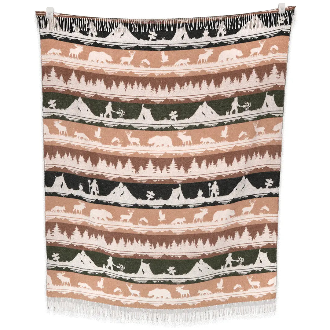 The Sackcloth & Ashes Smokey Bear Blanket - Smokey Ranger features a stunning nature-themed design with silhouettes of trees, mountains, animals, and hikers in muted earth tones. This distinctive blanket not only supports wildfire prevention but is also made from recycled materials for an eco-friendly touch.