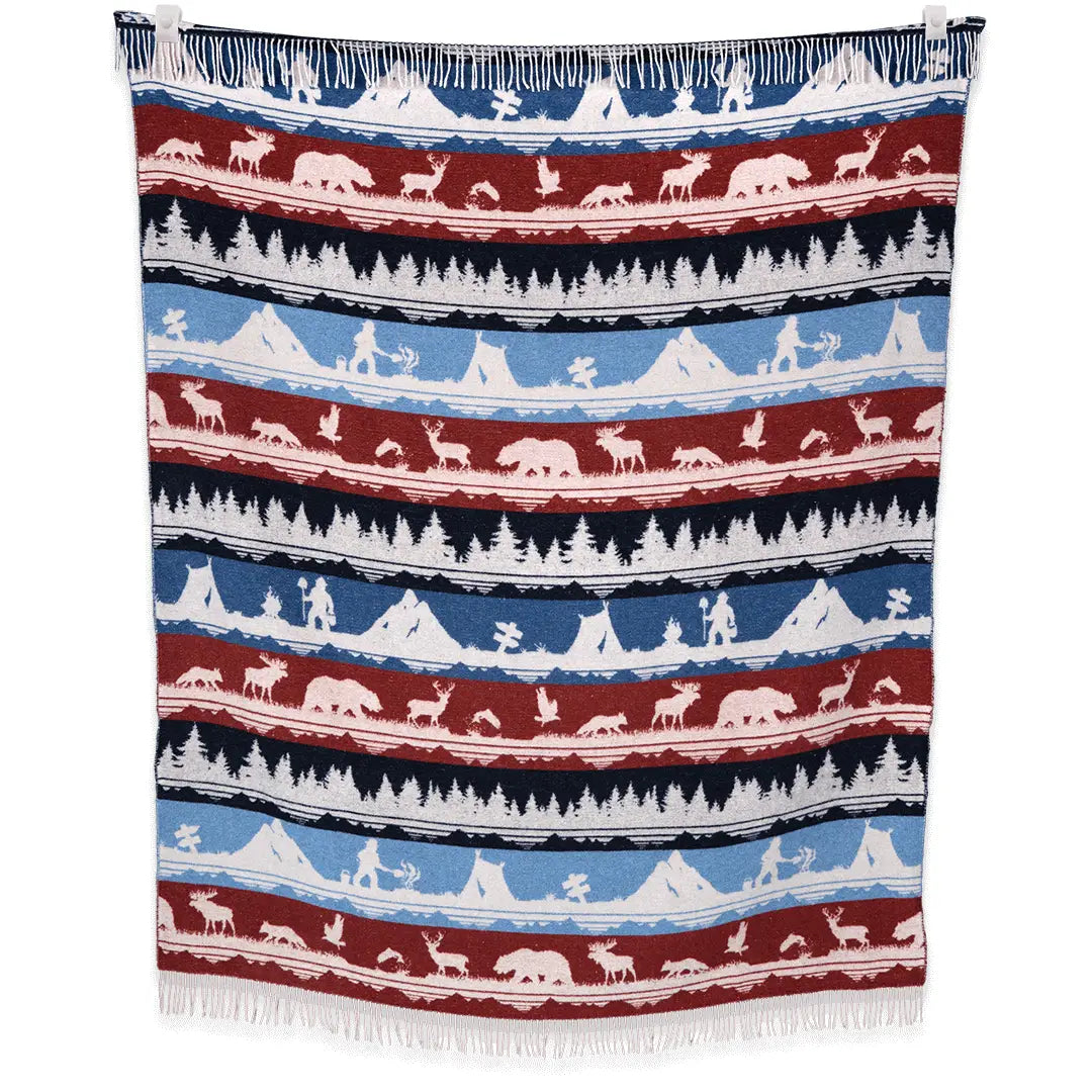 Consider donating a Sackcloth & Ashes Smokey Bear Blanket - Smokey Ramble to a homeless shelter for added warmth and comfort. This fringed blanket features horizontal stripes with mountain, forest, and animal patterns in blue, red, and white.