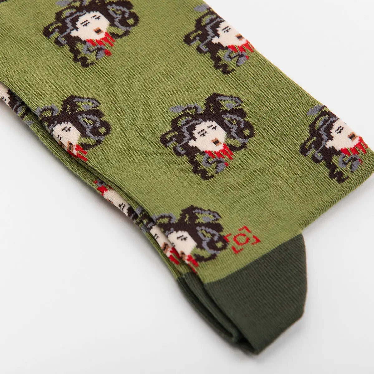 Sock Affairs Medusa Head Socks feature Greek mythology pixel art on sustainable cotton; unique Medusa face, eco-friendly design.