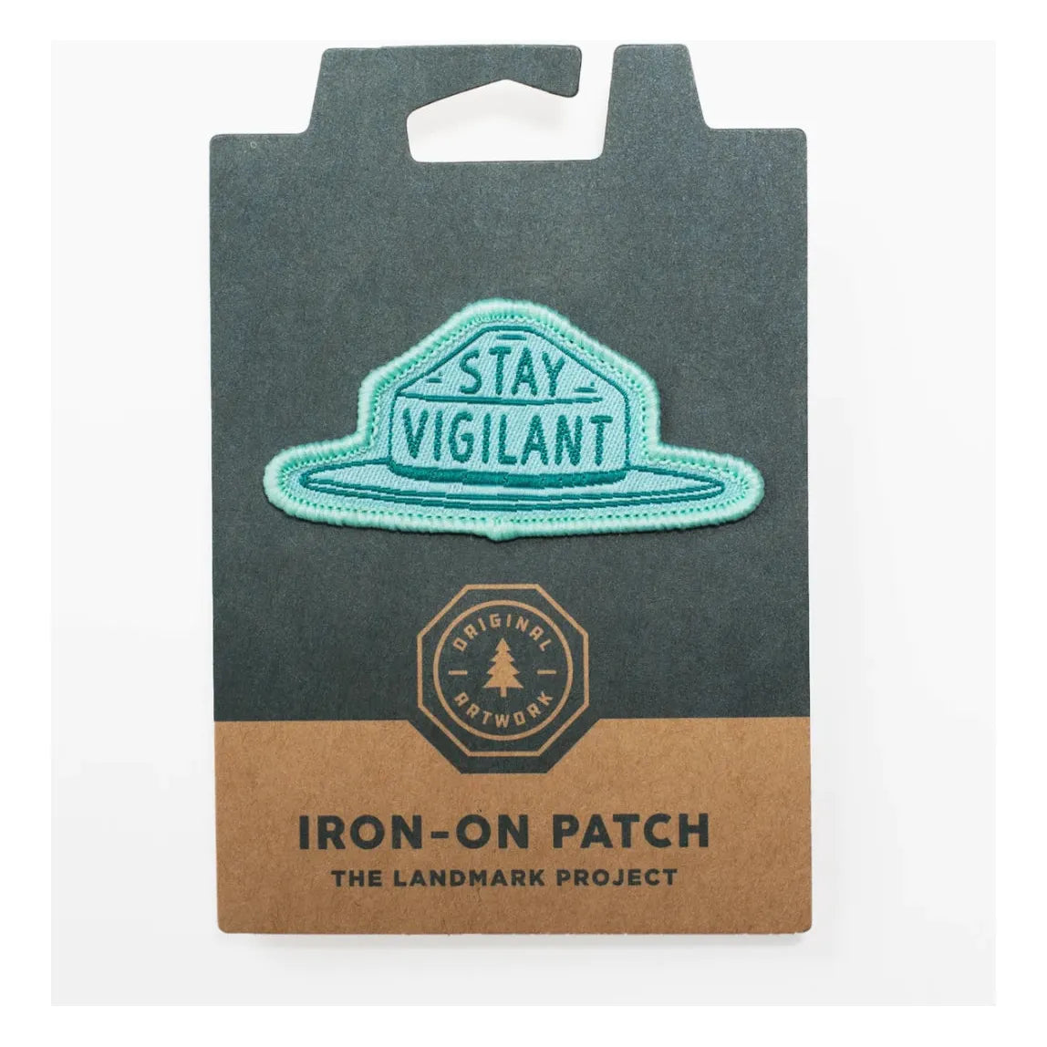 Teal iron-on patch featuring the phrase "STAY VIGILANT." Ideal for outdoor adventures, the packaging highlights "The Landmark Project," "Original Artwork," and includes sustainable materials. Official product name: The Landmark Project Smokey Bear Patch - Smokey Hat.