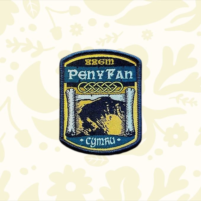 The Adventure Patch Company Pen Y Fan hiking patch souvenir displayed on rustic wood, perfect gift for hikers and collectors.