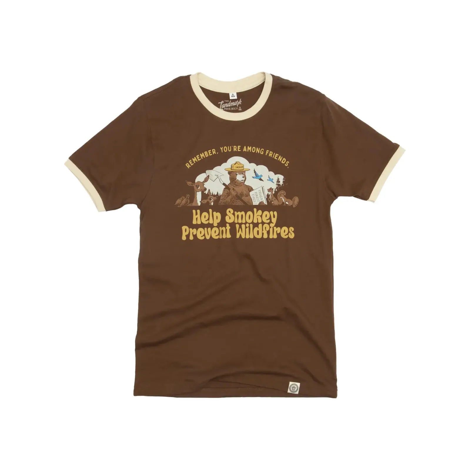 The Landmark Project Amongst Friends Smokey Bear T-Shirt in Walnut features a brown color with white trim, a message and illustration of Smokey Bear stating, "Remember, you’re among friends. Help Smokey prevent wildfires." As part of our sustainably made tees collection, this shirt promotes wildfire prevention education while supporting Smokey Bear products.