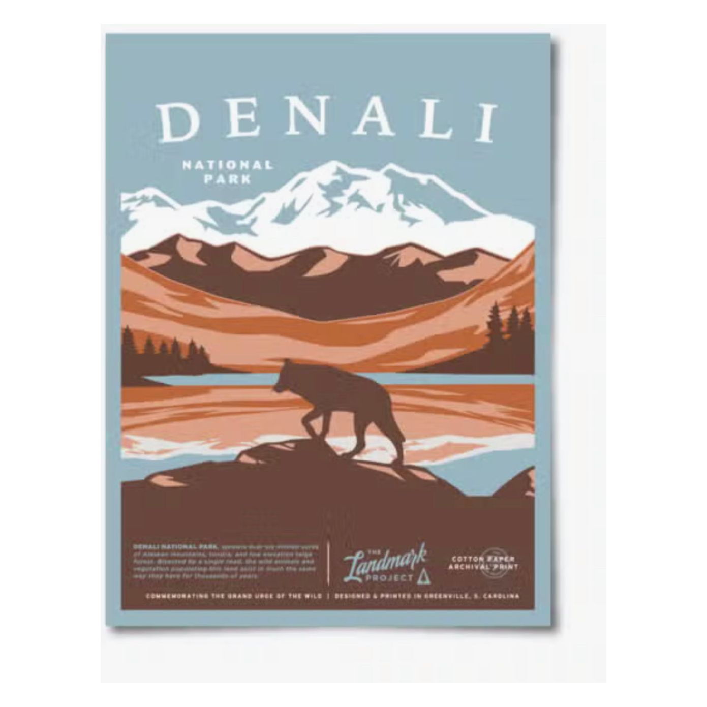 The Landmark Project Denali National Parks Poster 12x16 showcases a stunning illustration of a bear strolling near water against the majestic backdrop of mountains, printed on eco-friendly archival paper.