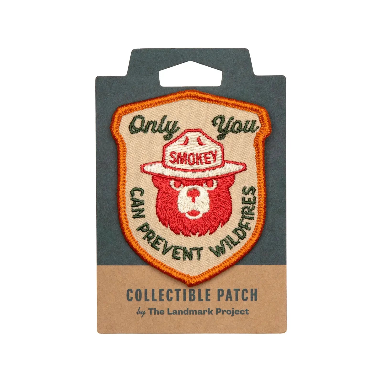 This licensed product, The Landmark Project Smokey Bear Patch - Only You Heritage, is an embroidered patch featuring Smokey Bear wearing a ranger hat and the text "Only You Can Prevent Wildfires." It is thoughtfully packaged by The Landmark Project.