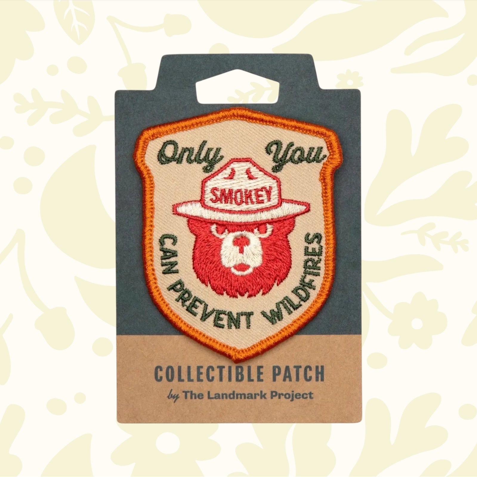 This licensed product, The Landmark Project Smokey Bear Patch - Only You Heritage, is an embroidered patch featuring Smokey Bear wearing a ranger hat and the text "Only You Can Prevent Wildfires." It is thoughtfully packaged by The Landmark Project.