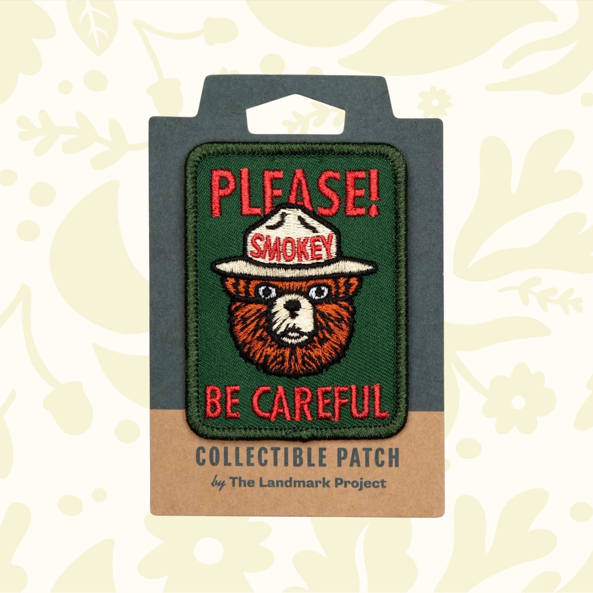 The official licensed "The Landmark Project Smokey Bear Patch - Please Becareful" from the USDA Forest Service features a collectible design of Smokey Bear with the text "PLEASE! BE CAREFUL." above and below him, supporting wildfire prevention education.