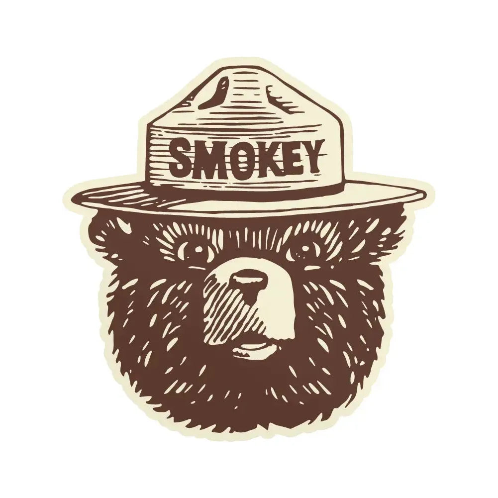 Illustration of a bear wearing a park ranger hat labeled "SMOKEY," representing Smokey Bear, a symbol for wildfire prevention. Perfect for weatherproof vinyl stickers to showcase in your adventure cataloging or add to your collection of park stickers. This description fits perfectly for The Landmark Project Smokey Bear Logo Sticker.