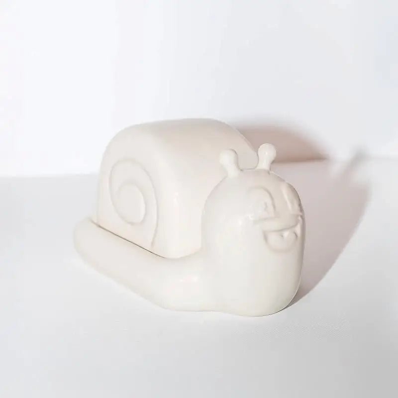 Snail-shaped butter dish by Third Drawer Down UK x Hattie Stewart, smiling face, quirky kitchen decor on white surface.