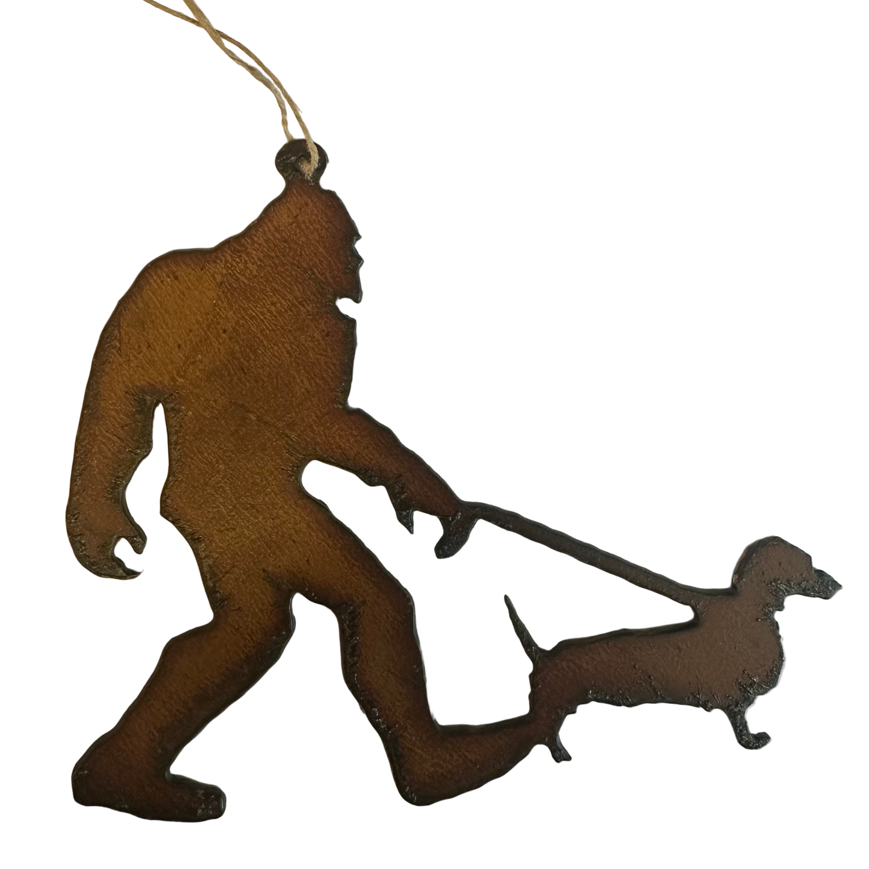 Brown silhouette of Bigfoot walking his or hers sausage dog on lead, on a white background