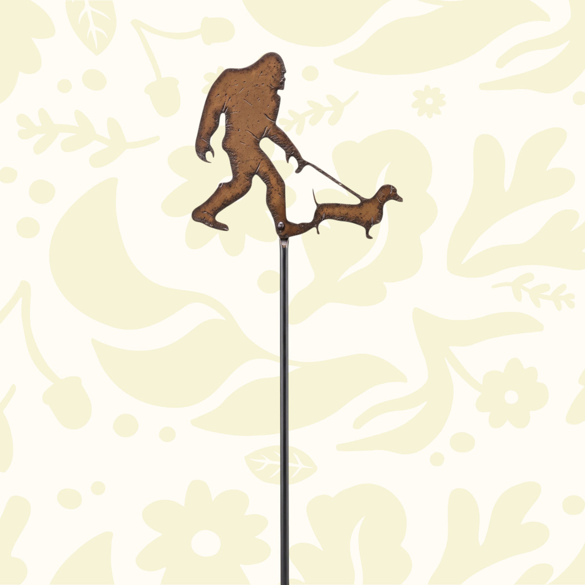 Universal Ironworks Bigfoot with Dachshund plant stake decor among yellow faux flowers, perfect yard art or garden decoration.