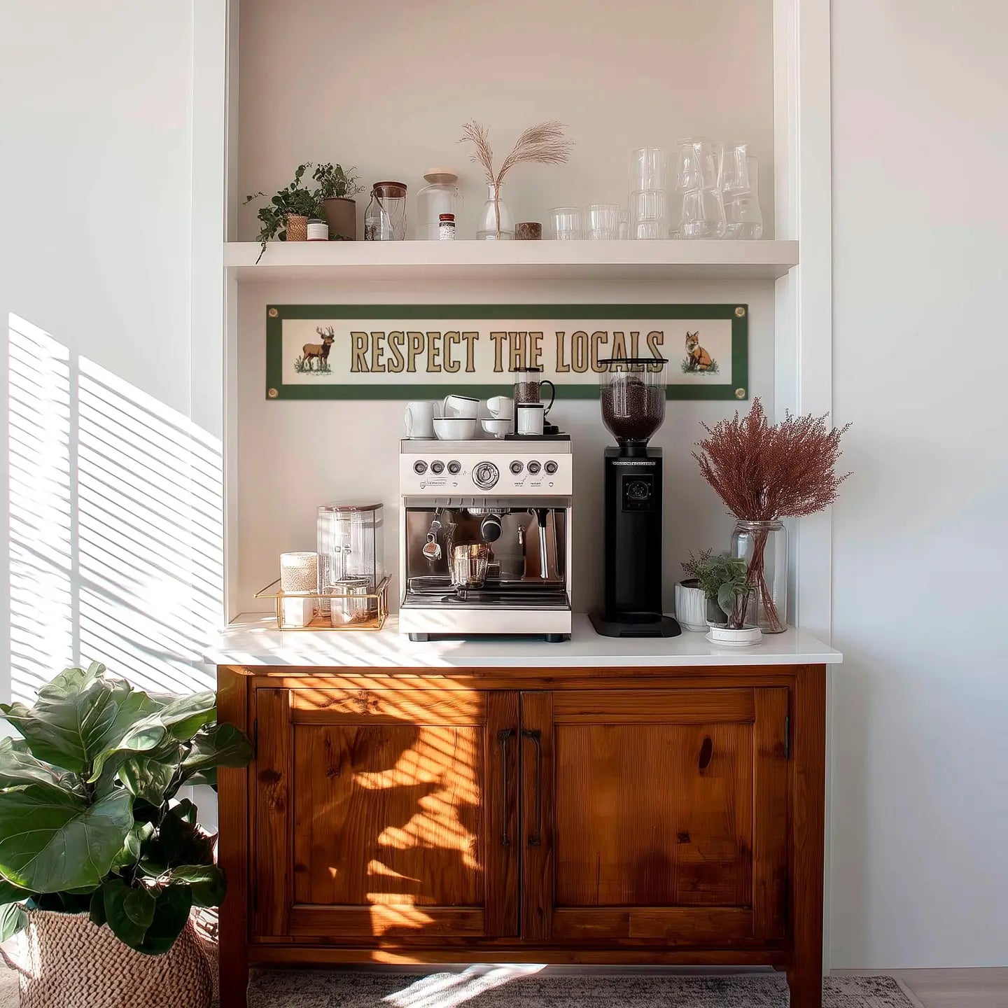 Modern coffee station setup with espresso machine, grinder, cups, and a "Respect Your Locals" Benoit pennant on the wall.