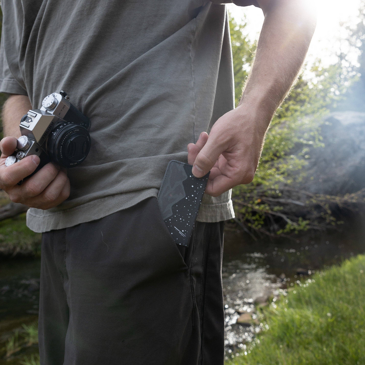 Forager Provisions LTD Wildtree Midnight Mountain card holder being placed into a pocket by a photographer outdoors