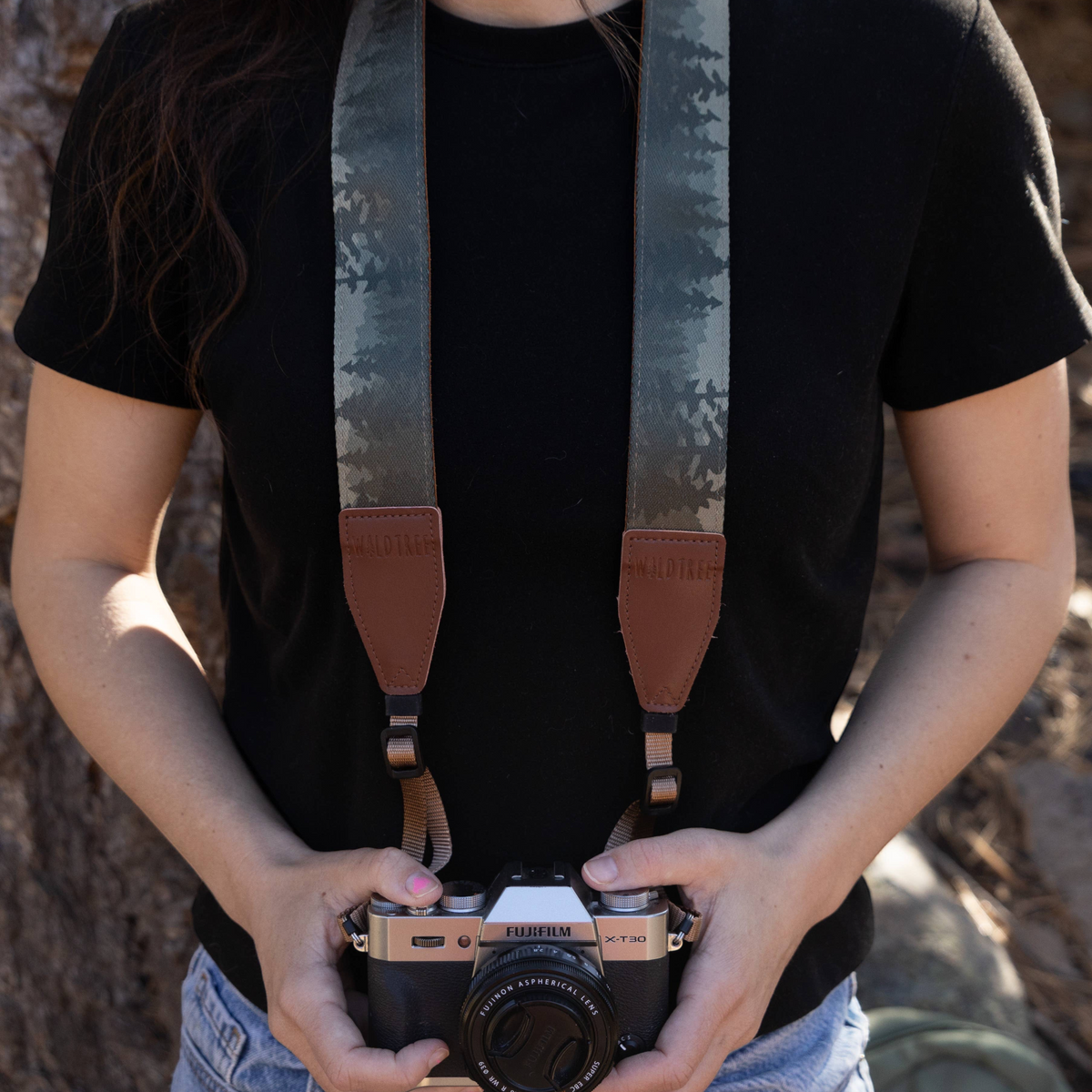 Forager Provisions LTD Wildtree Foggy Forest camera strap with mountain print and brown faux suede ends on a photographer