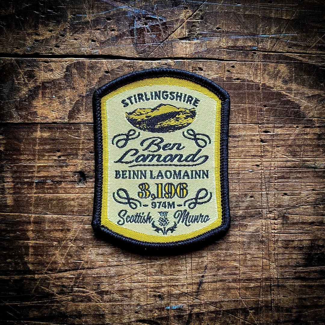 Forager Provisions LTD Ben Lomond embroidered patch featuring mountain silhouette, text, and yellow border on wood.