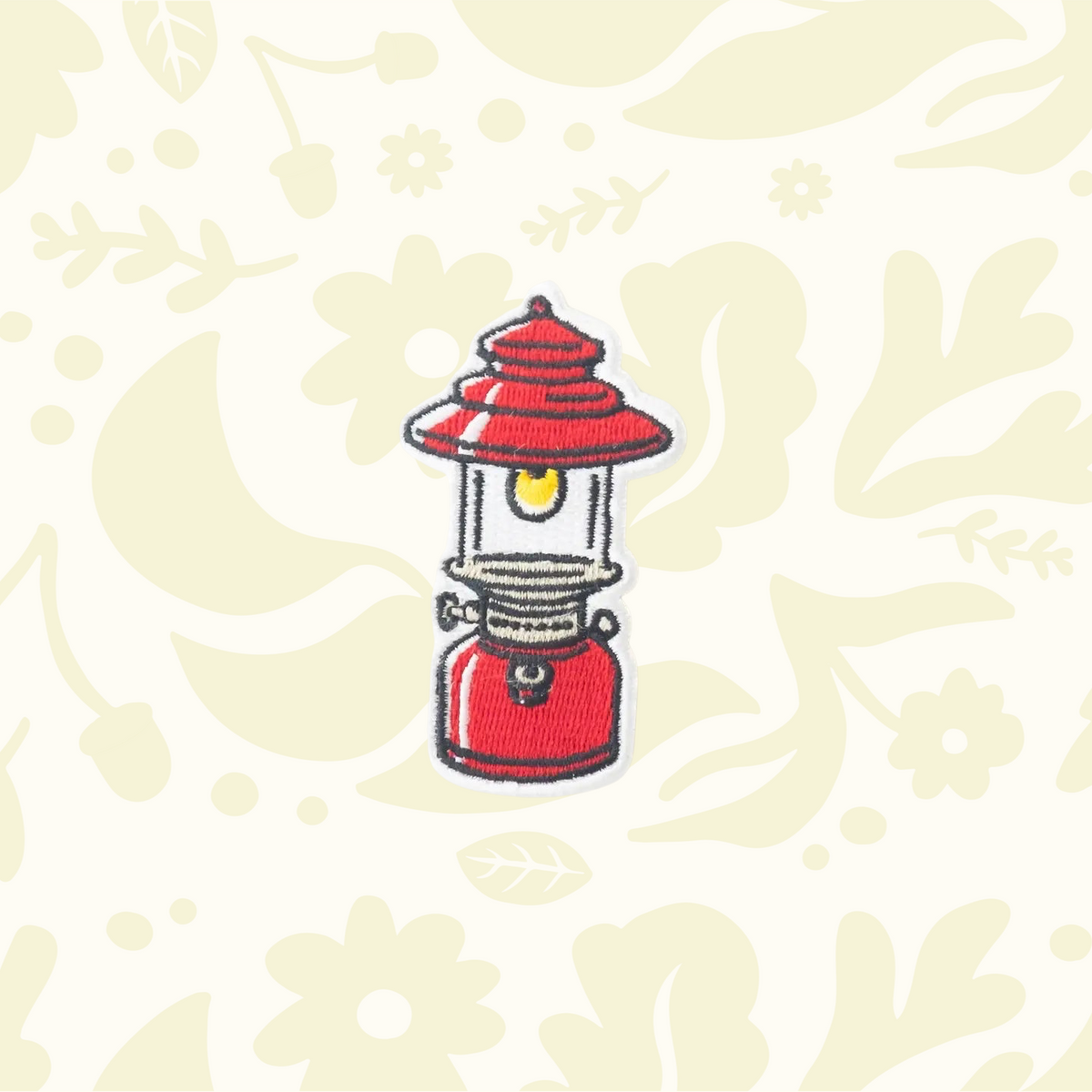 Forager Provisions LTD embroidered camping lantern patch with red and yellow details on a cream floral background.