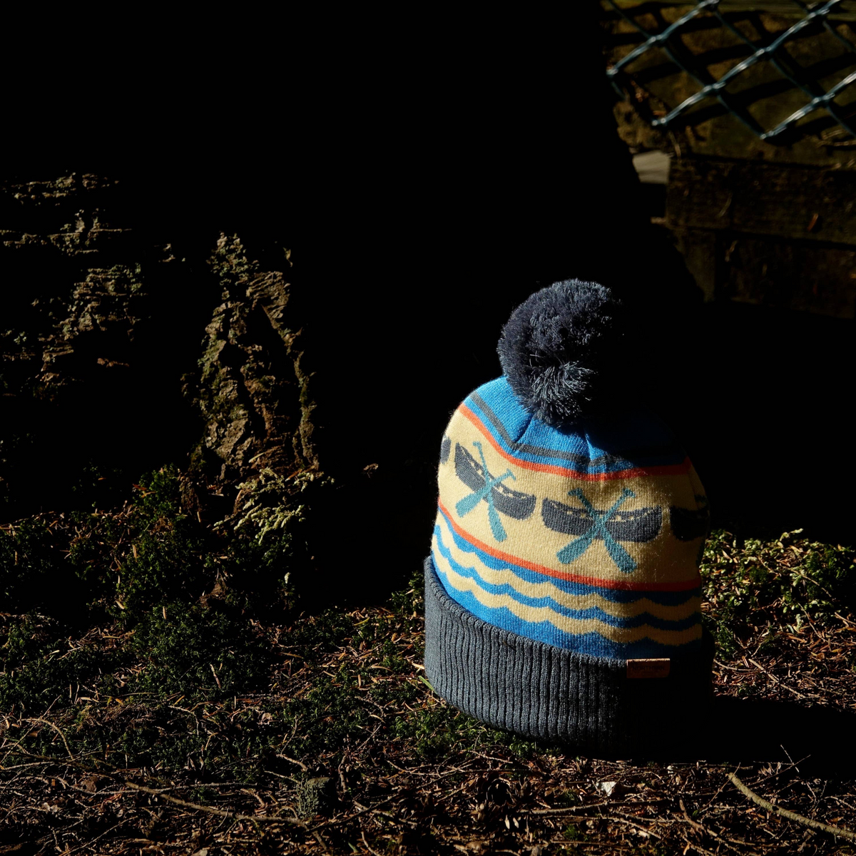 Forager Provisions LTD knit beanie with blue and cream canoe paddle pattern, ribbed cuff, and a fluffy pom pom.