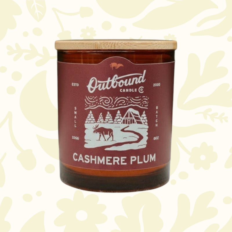 Forager Provisions LTD Cashmere Plum soy candle in an amber glass jar with a bamboo lid and winter-themed label.
