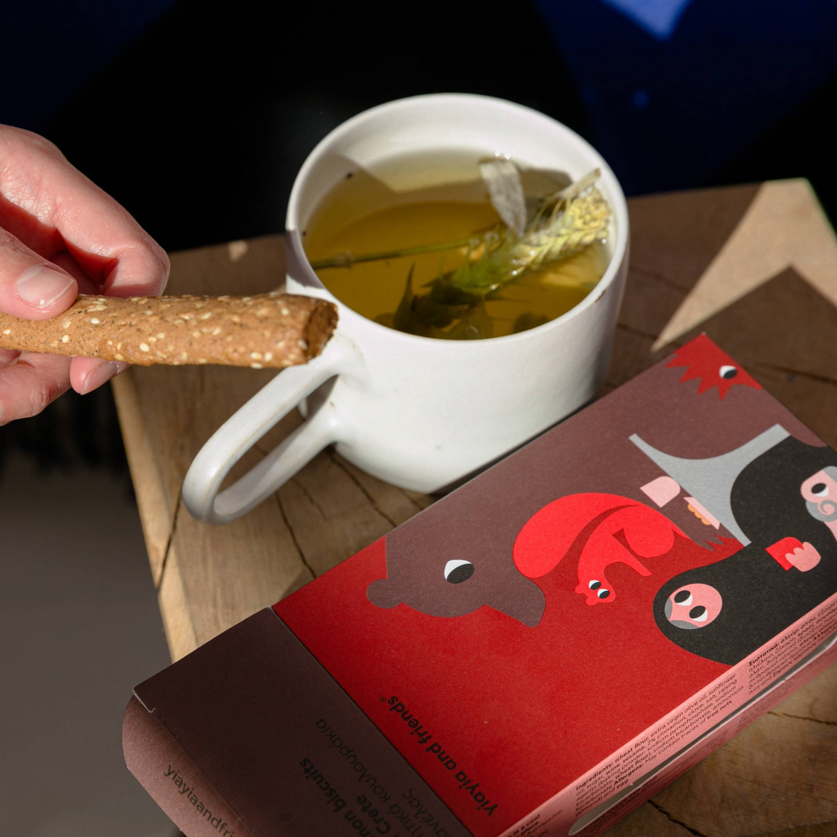 Forager Provisions LTD cinnamon biscuits from Crete being dipped into a cup of herbal tea on a wooden table.