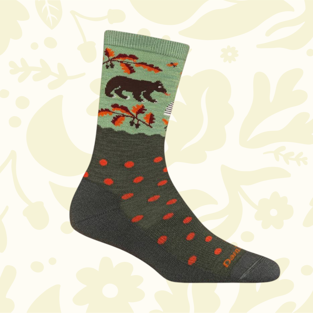 Darn Tough 6105 Women’s Bear In Woods green and gray sock with trees, bears pattern, red dots. Outdoor lifestyle design.
