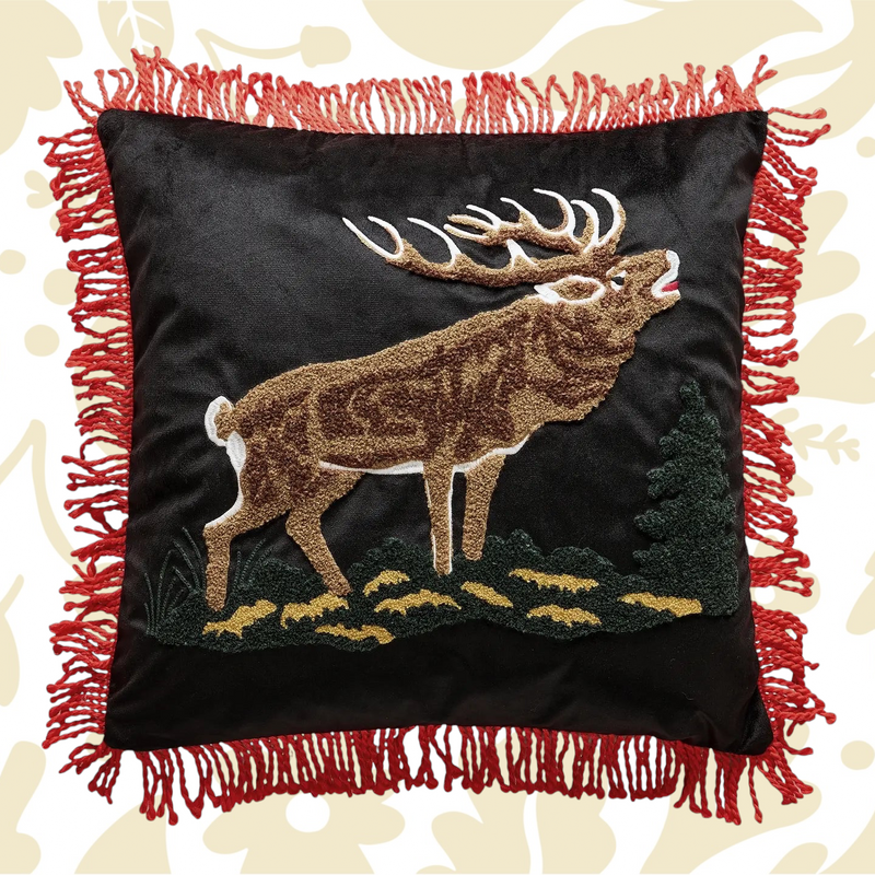 Forager Provisions LTD needle punch elk pillow on black fabric with red tassel trim and lodge-inspired design.
