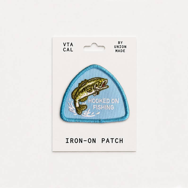 Forager Provisions LTD Hooked on Fishing embroidered iron-on patch featuring a bass fish on a blue triangular background.