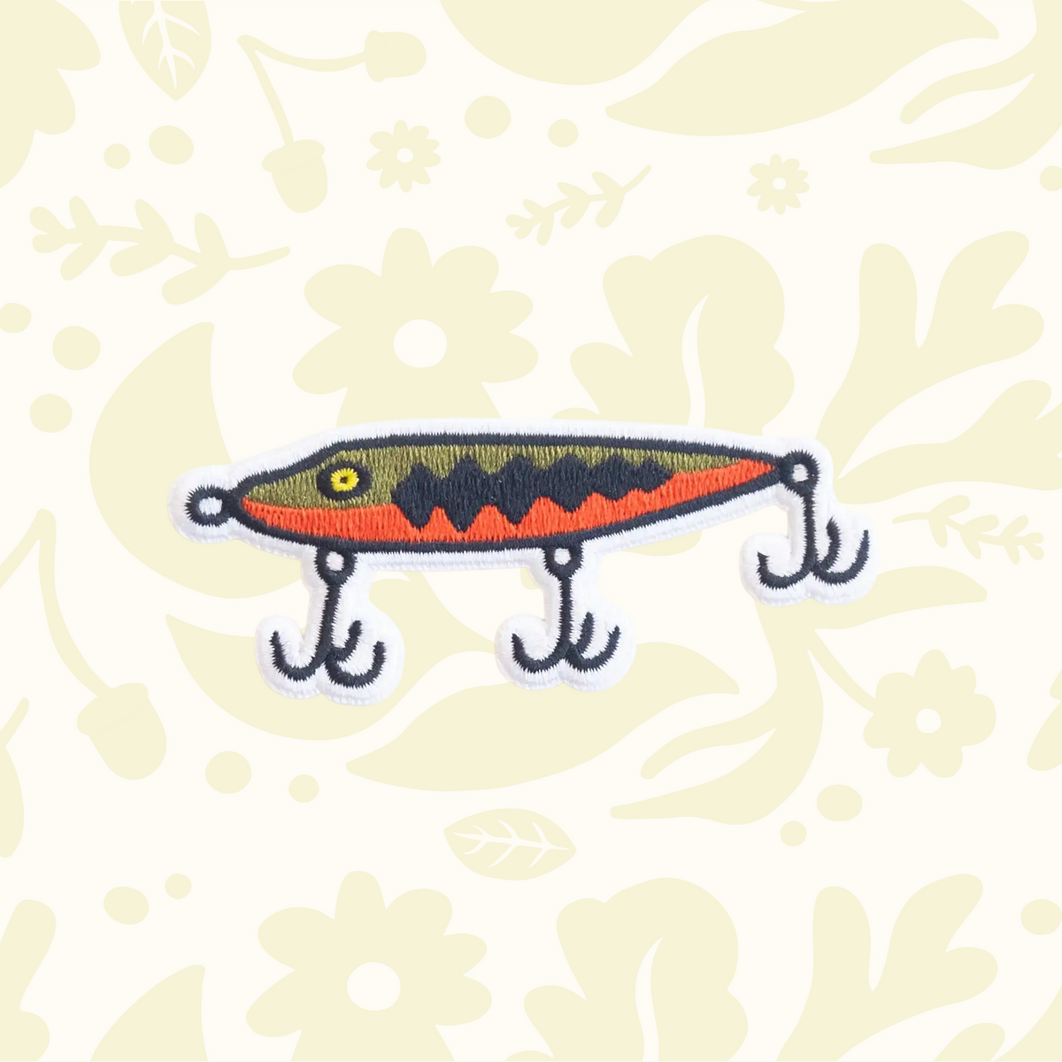 Forager Provisions LTD embroidered fishing lure patch with orange, olive, and black details on a white background.